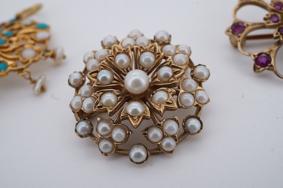 Two brooches and a pendant, each of floral design, the brooches set with circular-cut garnets, and seed pearls respectively each mounted in 9ct gold, British hallmarks, combined gross weight 11 grams, the pendant set wit